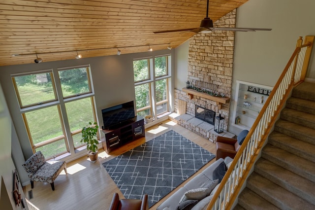 20428 Pheasant Trl, Brainerd, MN 56401 - living area featuring wooden ceiling, stairway, wood finished floors, a ceiling fan, and a stone fireplace