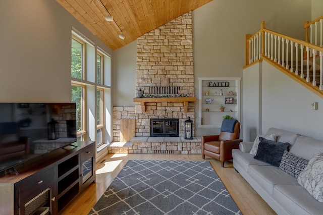 20428 Pheasant Trl, Brainerd, MN 56401 - living room featuring a stone fireplace, wooden ceiling, wood finished floors, high vaulted ceiling, and stairs