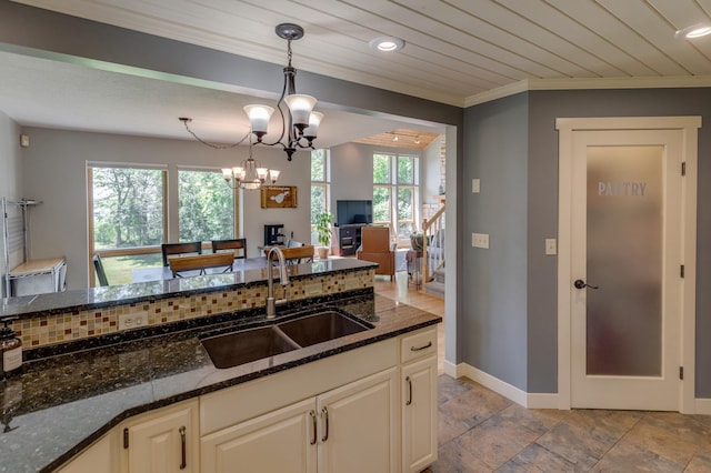 20428 Pheasant Trl, Brainerd, MN 56401 - kitchen with crown molding, dark stone counters, hanging light fixtures, stone tile flooring, and a chandelier