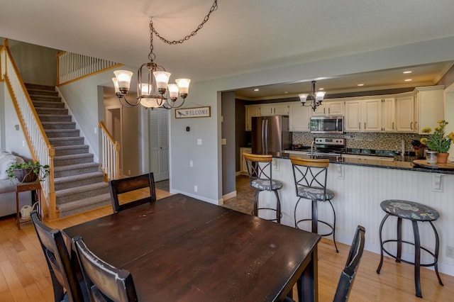 20428 Pheasant Trl, Brainerd, MN 56401 - dining room featuring a chandelier, light wood finished floors, stairway, and recessed lighting