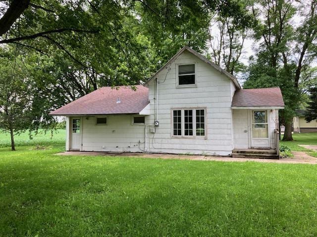 358 Cypress Ave, New Richland, MN 56072 - rear view of house with roof with shingles and a yard
