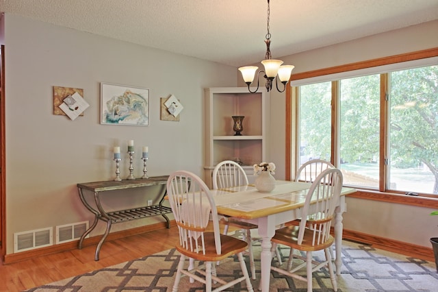13334 Silverod Ct NW, Andover, MN 55304 - dining room featuring a chandelier, light wood-style floors, and a textured ceiling