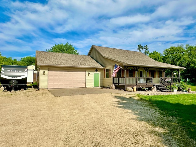 2161 170th St, New Richmond, WI 54017 - view of front facade with a porch, a garage, dirt driveway, and a front yard