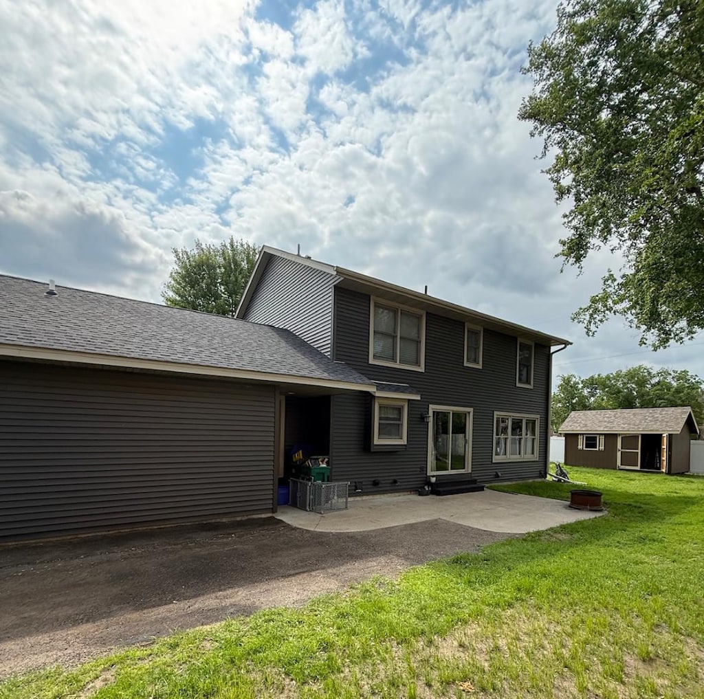 205 Evergreen Dr E, Cannon Falls, MN 55009 - back of house featuring a patio area, a yard, entry steps, an outdoor structure, and a garage
