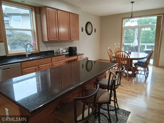 6640 Fountain Ct N, Maple Grove, MN 55311 - kitchen featuring light wood-style flooring, a kitchen bar, hanging light fixtures, dark stone counters, and stainless steel dishwasher