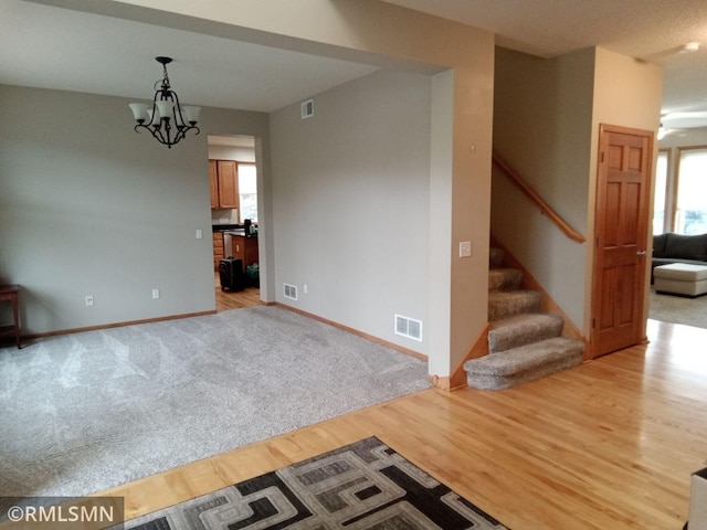 6640 Fountain Ct N, Maple Grove, MN 55311 - empty room featuring stairs, light wood finished floors, and a chandelier