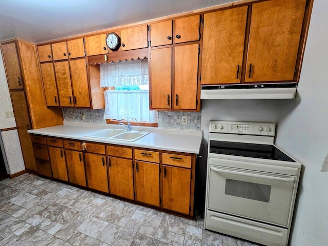 808 5th St SW, Pipestone, MN 56164 - kitchen featuring white electric range oven, under cabinet range hood, brown cabinets, light countertops, and tasteful backsplash