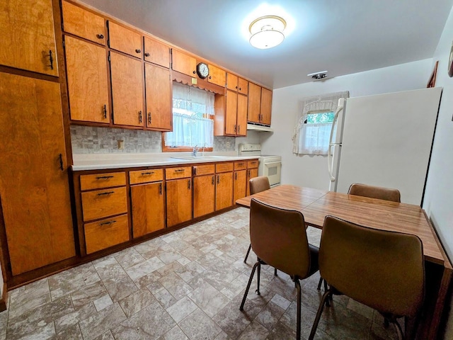 808 5th St SW, Pipestone, MN 56164 - kitchen featuring white appliances, light countertops, brown cabinets, and light stone finish flooring