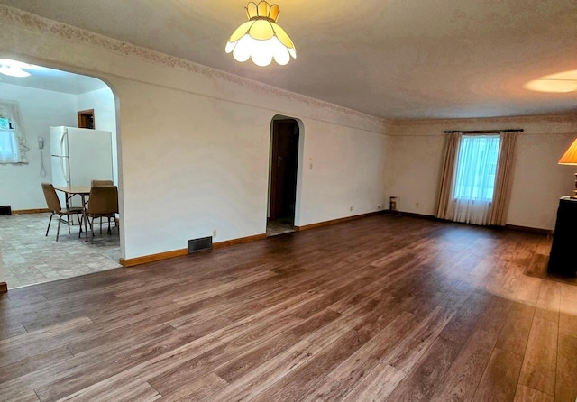 808 5th St SW, Pipestone, MN 56164 - unfurnished living room with arched walkways and wood finished floors