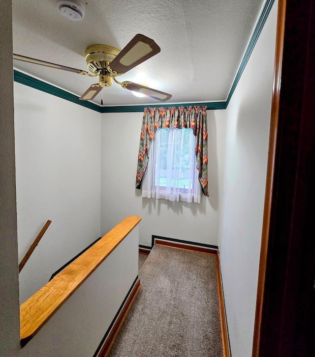 808 5th St SW, Pipestone, MN 56164 - hallway featuring a textured ceiling, an upstairs landing, ornamental molding, and carpet