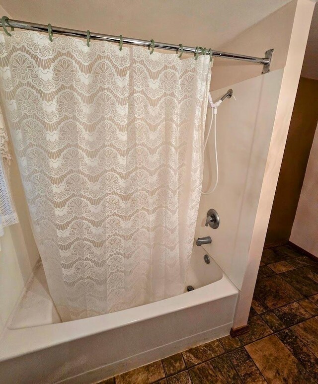 808 5th St SW, Pipestone, MN 56164 - bathroom featuring stone tile flooring and shower / bathtub combination with curtain