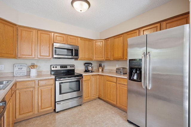 6520 Nathan Ln N, Maple Grove, MN 55369 - kitchen with appliances with stainless steel finishes, light countertops, and a textured ceiling