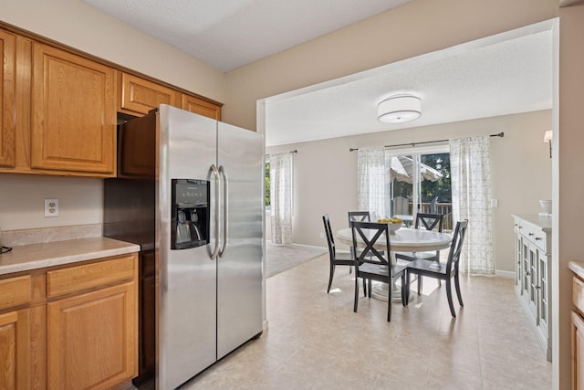 6520 Nathan Ln N, Maple Grove, MN 55369 - kitchen featuring stainless steel fridge with ice dispenser, light countertops, and brown cabinetry