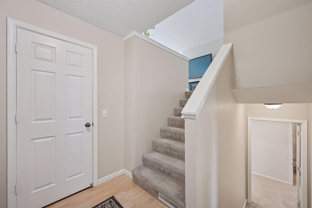 6520 Nathan Ln N, Maple Grove, MN 55369 - staircase with a textured ceiling and wood finished floors