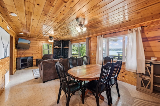 51122 Long Point Pl, Mcgregor, MN 55760 - dining space featuring light floors, a stone fireplace, wooden walls, a ceiling fan, and wood ceiling