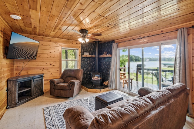 51122 Long Point Pl, Mcgregor, MN 55760 - living area with a wood stove, wood walls, wooden ceiling, a water view, and a ceiling fan