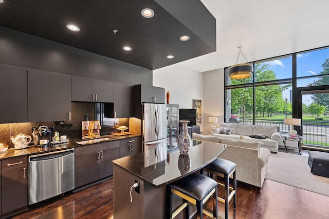 215 10th Ave S Unit 112, Minneapolis, MN 55415 - kitchen with stainless steel appliances, dark wood-type flooring, open floor plan, a breakfast bar, and recessed lighting