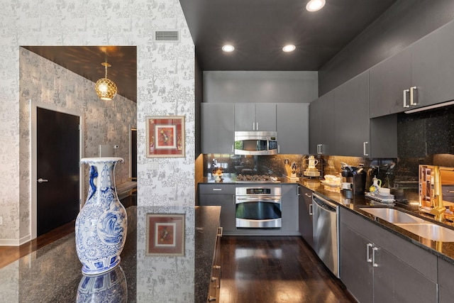 215 10th Ave S Unit 112, Minneapolis, MN 55415 - kitchen with appliances with stainless steel finishes, wallpapered walls, dark wood-style flooring, recessed lighting, and gray cabinets