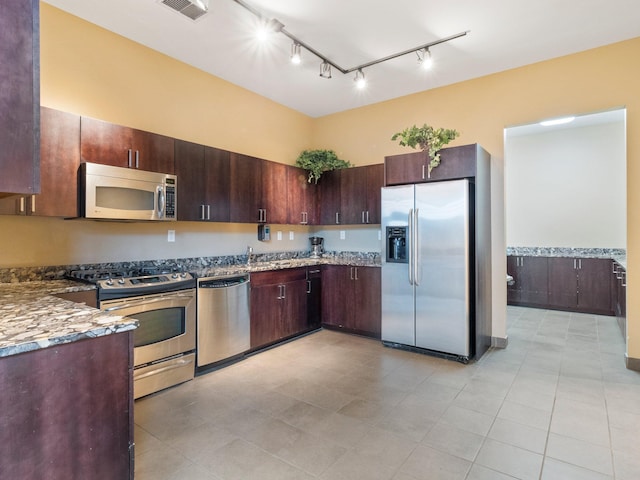 215 10th Ave S Unit 112, Minneapolis, MN 55415 - kitchen with appliances with stainless steel finishes, track lighting, light tile patterned floors, and dark brown cabinets
