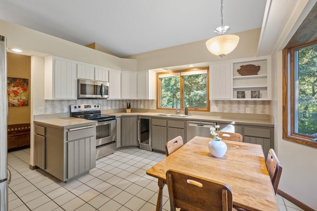 11409 Bren Rd, Minnetonka, MN 55343 - kitchen featuring stainless steel appliances, beverage cooler, light countertops, backsplash, and lofted ceiling
