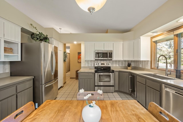 11409 Bren Rd, Minnetonka, MN 55343 - kitchen featuring stainless steel appliances, tasteful backsplash, white cabinetry, light countertops, and light tile patterned flooring