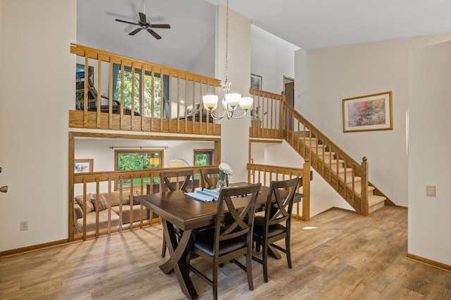 11409 Bren Rd, Minnetonka, MN 55343 - dining space with high vaulted ceiling, a chandelier, wood finished floors, a ceiling fan, and stairway