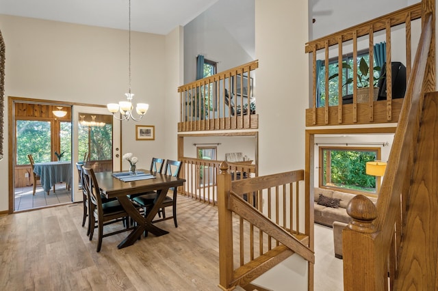 11409 Bren Rd, Minnetonka, MN 55343 - dining room featuring a high ceiling, a chandelier, and wood finished floors
