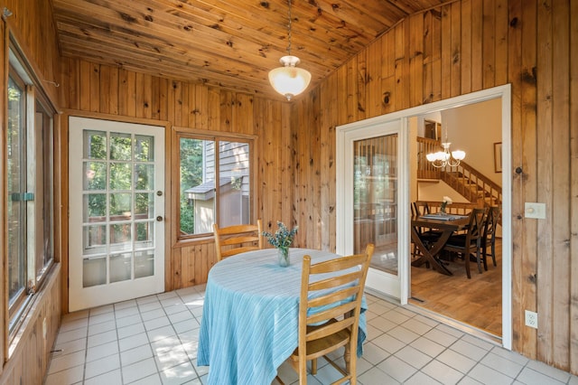 11409 Bren Rd, Minnetonka, MN 55343 - dining room with light tile patterned floors, lofted ceiling, wood walls, a chandelier, and wooden ceiling