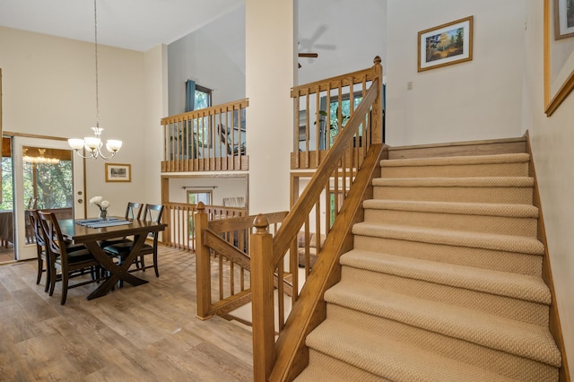 11409 Bren Rd, Minnetonka, MN 55343 - staircase with a towering ceiling, a chandelier, wood finished floors, and a ceiling fan