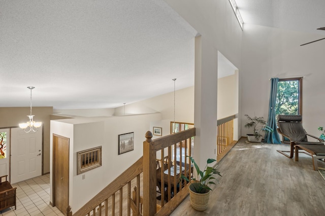 11409 Bren Rd, Minnetonka, MN 55343 - corridor featuring a chandelier, lofted ceiling, an upstairs landing, light wood finished floors, and a textured ceiling