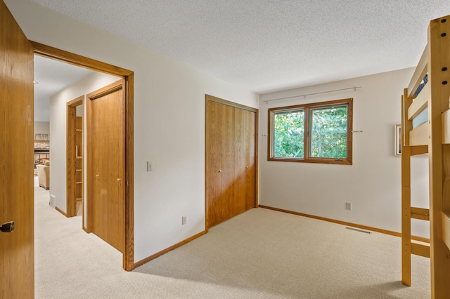 11409 Bren Rd, Minnetonka, MN 55343 - unfurnished bedroom with carpet, a closet, and a textured ceiling