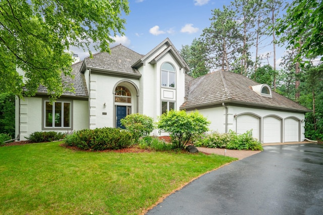 7005 Valley View Rd, Edina, MN 55439 - view of front of house featuring stucco siding, a front lawn, a garage, and asphalt driveway