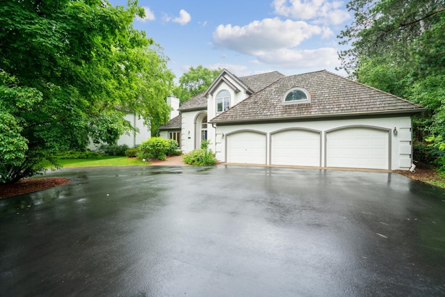 7005 Valley View Rd, Edina, MN 55439 - view of front of house with asphalt driveway, a garage, stucco siding, and a chimney