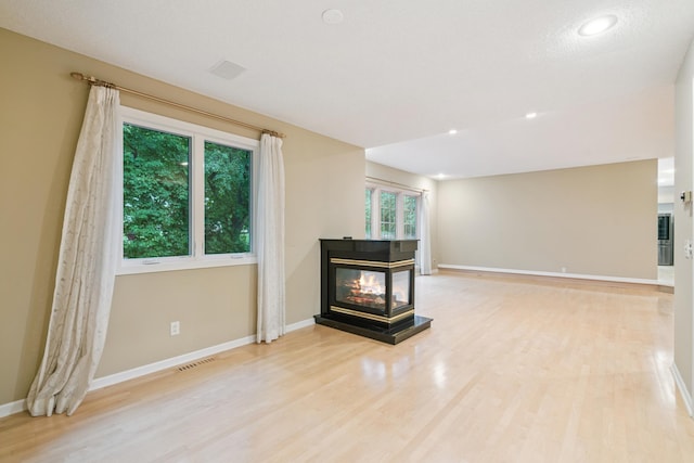 7005 Valley View Rd, Edina, MN 55439 - unfurnished living room featuring light wood-style flooring, a multi sided fireplace, and recessed lighting