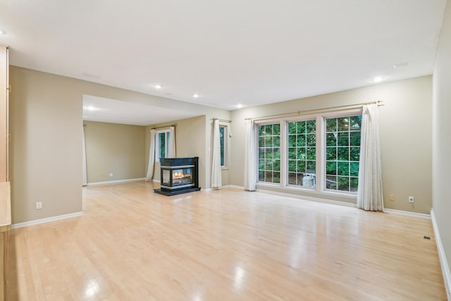 7005 Valley View Rd, Edina, MN 55439 - unfurnished living room with light wood-style floors, recessed lighting, and a multi sided fireplace