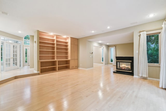 7005 Valley View Rd, Edina, MN 55439 - unfurnished living room featuring light wood-style flooring, a multi sided fireplace, recessed lighting, and built in features