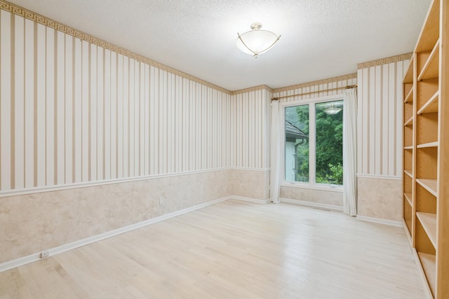 7005 Valley View Rd, Edina, MN 55439 - empty room featuring wallpapered walls, wood finished floors, and a textured ceiling