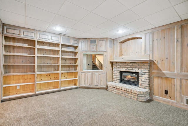 7005 Valley View Rd, Edina, MN 55439 - unfurnished living room with a paneled ceiling, carpet, wooden walls, a brick fireplace, and recessed lighting