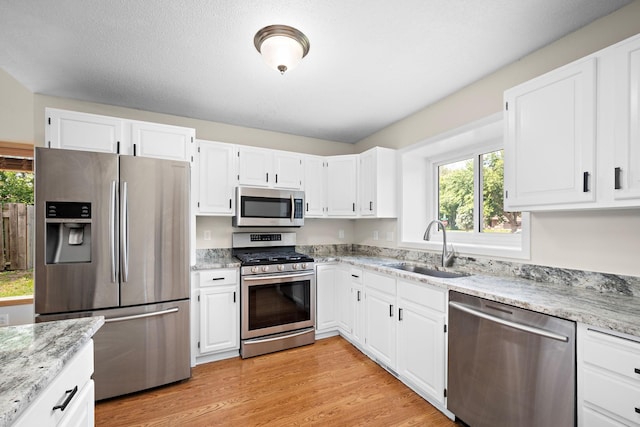 16391 Adret Ct, Eden Prairie, MN 55346 - kitchen featuring appliances with stainless steel finishes, light stone counters, and white cabinetry