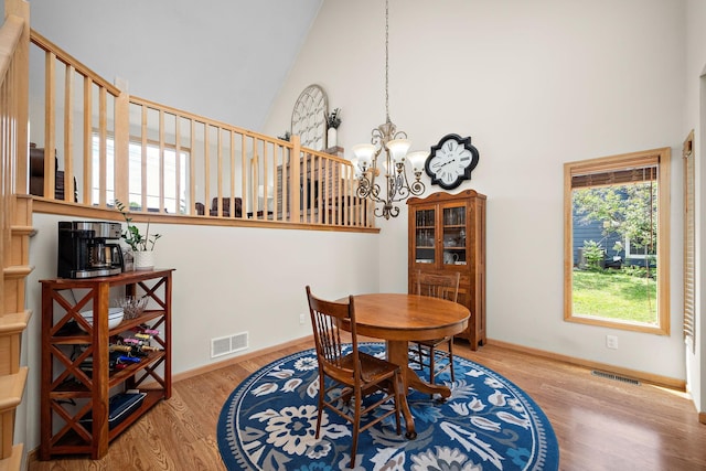 16391 Adret Ct, Eden Prairie, MN 55346 - dining area with high vaulted ceiling, a chandelier, and wood finished floors