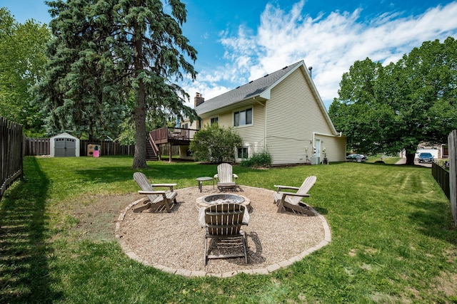 16391 Adret Ct, Eden Prairie, MN 55346 - fenced backyard featuring a fire pit, a deck, stairs, and a storage unit