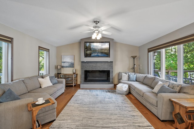 27858 Nathan Ln, Chisago Lake Twp, MN 55045 - living area with vaulted ceiling, a glass covered fireplace, a ceiling fan, and light wood-style floors