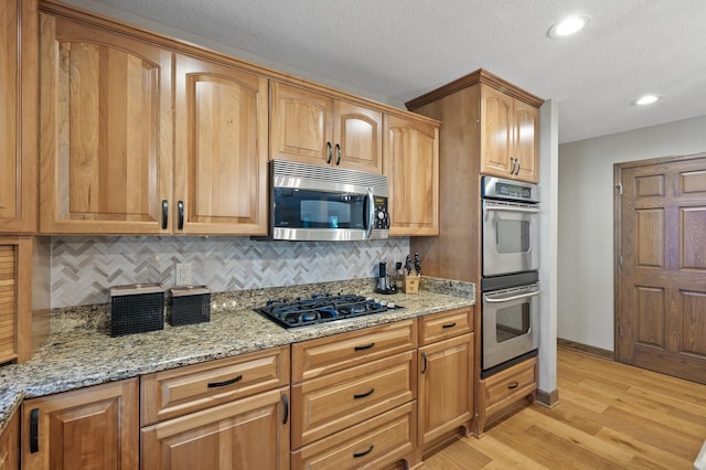 27858 Nathan Ln, Chisago Lake Twp, MN 55045 - kitchen featuring stainless steel appliances, light wood-style floors, tasteful backsplash, light stone countertops, and recessed lighting