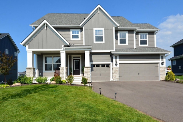 5120 Coronado Dr, Woodbury, MN 55129 - craftsman house with a front yard, asphalt driveway, a garage, a shingled roof, and covered porch