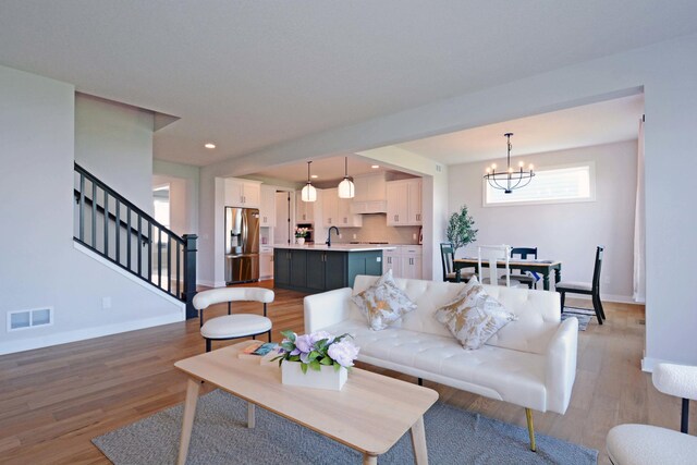 5120 Coronado Dr, Woodbury, MN 55129 - living room featuring a chandelier, light wood-style flooring, stairway, and recessed lighting
