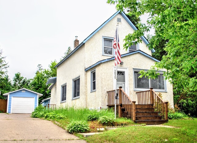 1015 Grove St, Brainerd, MN 56401 - view of front of house with stucco siding, concrete driveway, an outdoor structure, a garage, and a chimney