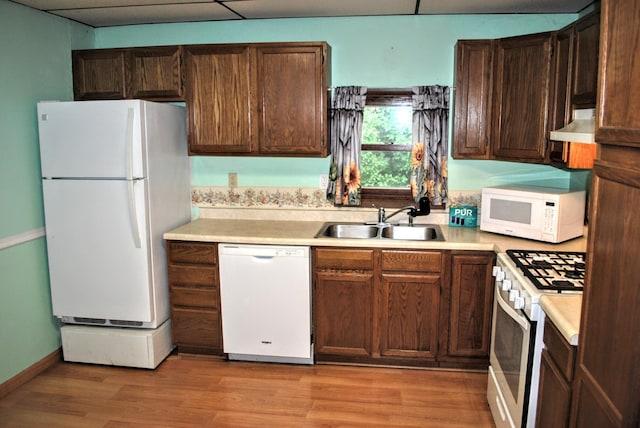 1015 Grove St, Brainerd, MN 56401 - kitchen featuring white appliances, light countertops, light wood finished floors, wall chimney exhaust hood, and dark brown cabinetry