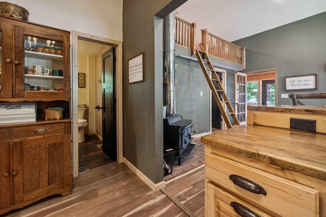 38985 337th Ln, Aitkin, MN 56431 - kitchen with dark wood-type flooring, french doors, a wood stove, glass insert cabinets, and butcher block countertops