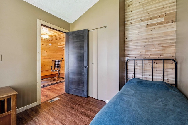 38985 337th Ln, Aitkin, MN 56431 - bedroom featuring wood walls, wood finished floors, vaulted ceiling, and a closet