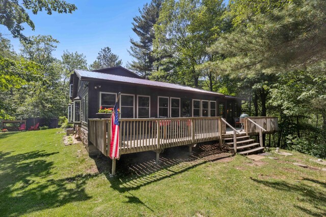 38985 337th Ln, Aitkin, MN 56431 - back of property with a deck, a lawn, and a metal roof
